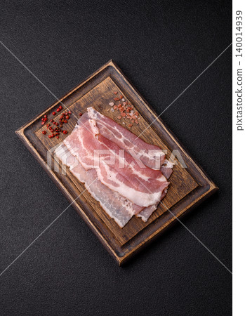 Raw fresh bacon slices with layers of meat or prosciutto with salt and spices. Raw bacon Raw fresh bacon slices with layers of meat or prosciutto with salt and spices. Raw bacon 140014939