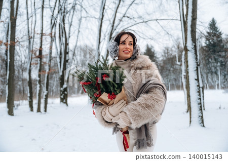 Woman in winter attire, holding a festive bouquet of evergreen branches with red accents, standing in a snowy forest, capturing the essence of holiday cheer and seasonal beauty Woman in winter attire, holding a festive bouquet of evergreen branches with red accents, standing in a snowy forest, capturing the essence of holiday cheer and seasonal beauty 140015143