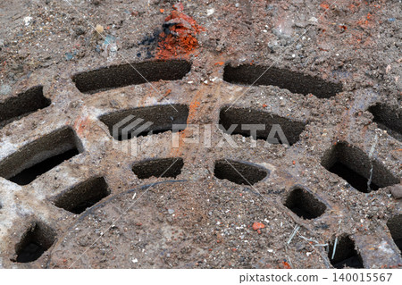 Close-Up Rusty Manhole Cover Partially Buried in Dirt and Debris on Urban Street Close-Up Rusty Manhole Cover Partially Buried in Dirt and Debris on Urban Street 140015567