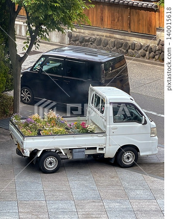 A white mini-truck loaded with colorful flowers A white mini-truck loaded with colorful flowers 140015618