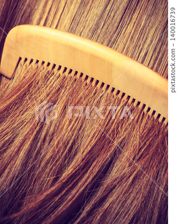 Straight brown hair with wooden comb closeup 140016739