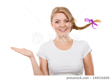 Happy teenage girl in braid hair presenting hand Happy teenage girl in braid hair presenting hand 140016899