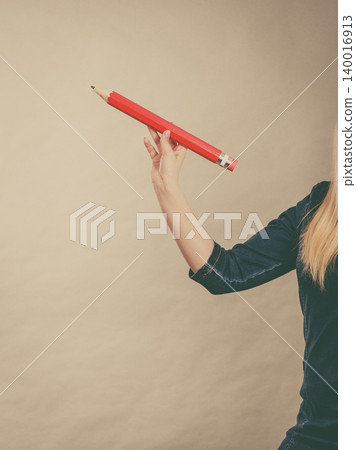 Female hand holds big red pencil Female hand holds big red pencil 140016913