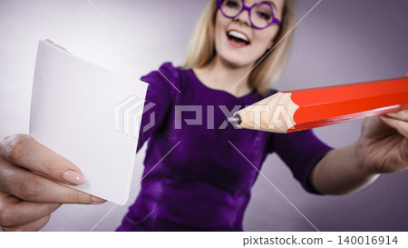 Crazy woman holds big pencil in hand Crazy woman holds big pencil in hand 140016914