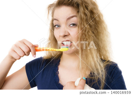 Grumpy tired woman brushing teeth, isolated Grumpy tired woman brushing teeth, isolated 140016939