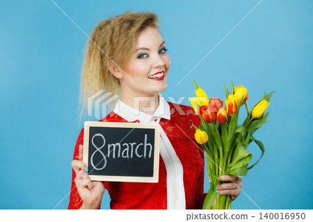 Woman holds tulips, board with text 8 march Woman holds tulips, board with text 8 march 140016950