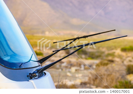 Black windshield wipers raised on camper vehicle hood 140017001
