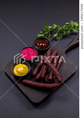 Smoked sausages and various dipping sauces on wooden board Smoked sausages and various dipping sauces on wooden board 140017099
