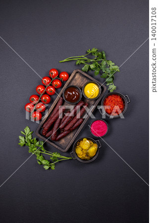 Smoked sausages with various condiments and fresh vegetables Smoked sausages with various condiments and fresh vegetables 140017108