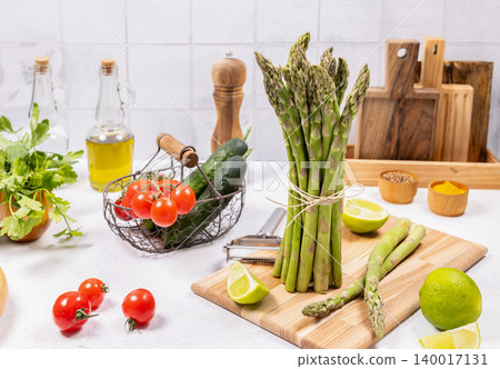 Fresh asparagus bundle and healthy cooking ingredients on kitchen counter 140017131