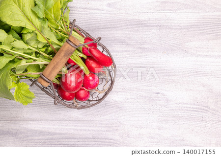 Fresh radishes with green leaves in a basket Fresh radishes with green leaves in a basket 140017155