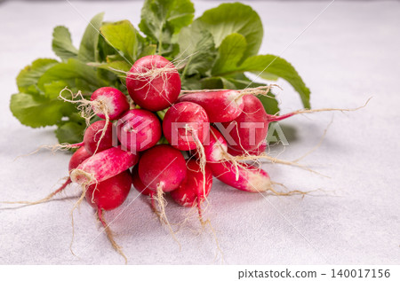 Fresh harvest of red radishes with green leaves Fresh harvest of red radishes with green leaves 140017156