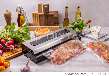 Vacuum sealer preserving meat and fresh ingredients on kitchen counter 140017161