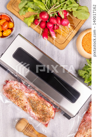Vacuum sealer packing raw meat for food preservation 140017162