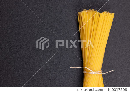 Uncooked spaghetti forming bunch tied with string Uncooked spaghetti forming bunch tied with string 140017208