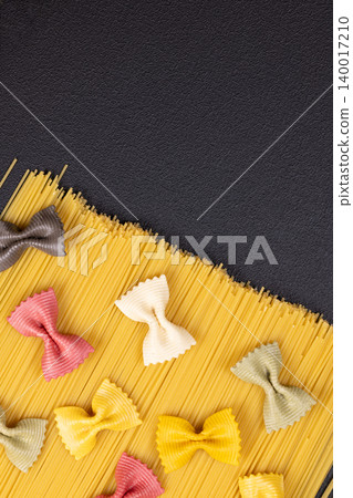 Assortment of colorful farfalle pasta on spaghetti background Assortment of colorful farfalle pasta on spaghetti background 140017210
