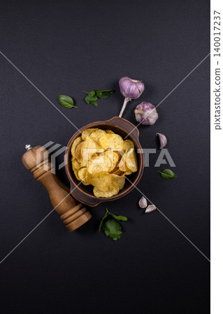 Potato chips served with garlic and fresh herbs 140017237