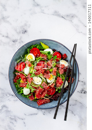 salad with fresh tuna, cherry tomatoes and quail eggs and avacado, served with chopsticks, salad with fresh tuna, cherry tomatoes and quail eggs and avacado, served with chopsticks, 140017311