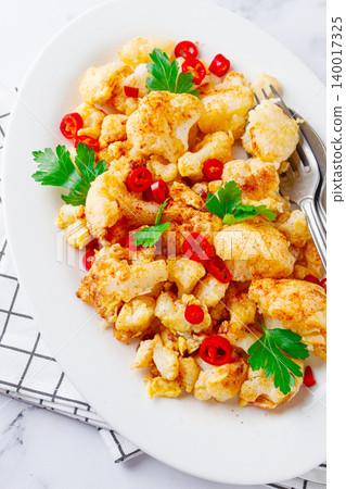 Cauliflower dish, with chili pepper and parsley, on a white plate served on a marble countertop, Cauliflower dish, with chili pepper and parsley, on a white plate served on a marble countertop, 140017325