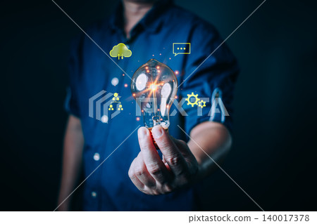 person hold a glowing light bulb symbolizing creativity, innovation, digital transformation, and new ideas with cloud, communication, and technology icons floating around for modern business concepts. person hold a glowing light bulb symbolizing creativity, innovation, digital transformation, and new ideas with cloud, communication, and technology icons floating around for modern business concepts. 140017378