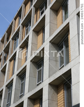 Modern apartment building facade shows concrete grid, wood cladding and recessed windows Modern apartment building facade shows concrete grid, wood cladding and recessed windows 140017781