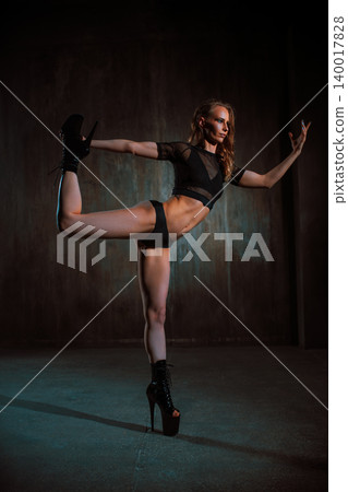 Young sexy woman dancer posing on dark wall background Young sexy woman dancer posing on dark wall background 140017828