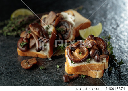Sandwiches with cream cheese, shiitake and shimeji mushrooms, lime wedges and sprigs of thyme. Sandwiches with cream cheese, shiitake and shimeji mushrooms, lime wedges and sprigs of thyme. 140017874