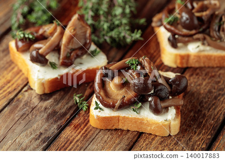 Sandwiches with baked mushrooms on an old wooden table. 140017883