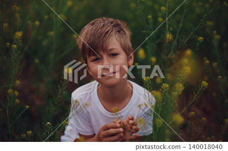 Portrait of seven-year-old boy in a flower meadow Portrait of seven-year-old boy in a flower meadow 140018040
