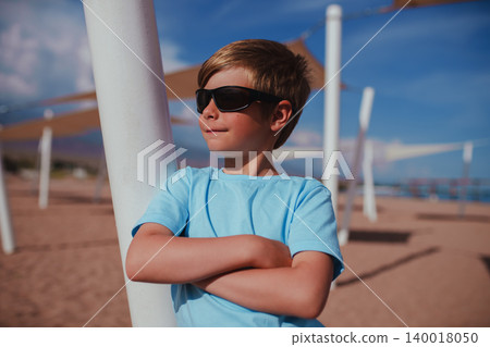 Portrait of handsome boy with sunglasses on the beach 140018050