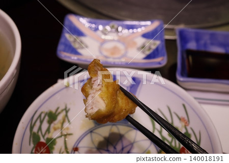 Fried Fish Bite with Chopsticks on Traditional Plate Fried Fish Bite with Chopsticks on Traditional Plate 140018191