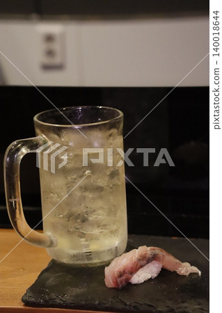 Glass Mug with Liquid and Raw Fish on Slate Glass Mug with Liquid and Raw Fish on Slate 140018644