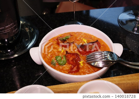 Risotto with Tomatoes and Basil in White Bowl 140018728