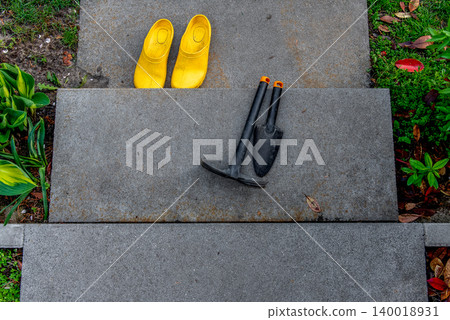 Garden hand tools on concrete stairs in outdoor setting. 140018931