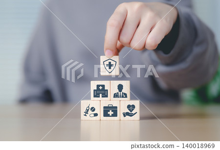 Health insurance and medical care concept. Woman placing wooden blocks with health-related icons, medical care, health insurance, and medication. healthcare services, protection, insurance coverage, Health insurance and medical care concept. Woman placing wooden blocks with health-related icons, medical care, health insurance, and medication. healthcare services, protection, insurance coverage, 140018969