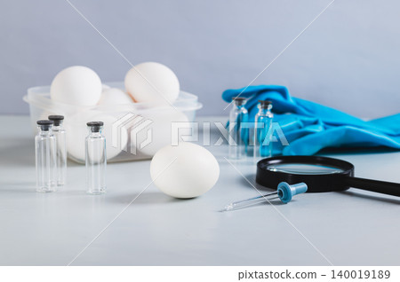 Salmonella concept, chicken egg, pipette and magnifying glass on the table 140019189