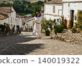 Woman traveling in small Spanish village with medieval cobblestone streets and mountain views 140019322