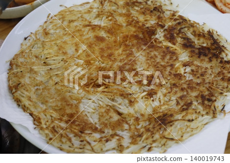 Golden Hash Brown Latke on White Plate 140019743