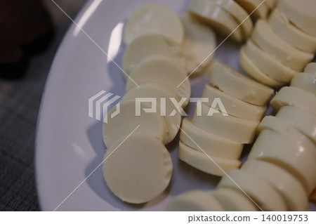 Sliced Cheese on White Plate Close-Up Sliced Cheese on White Plate Close-Up 140019753
