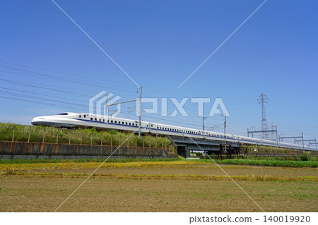 The Tokaido Shinkansen N700A runs through a sunny rural landscape. The Tokaido Shinkansen N700A runs through a sunny rural landscape. 140019920