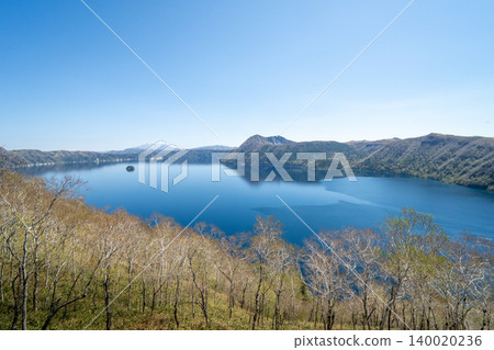 A distant view of Lake Akan, where the blue of the clear sky shines brightly. A distant view of Lake Akan, where the blue of the clear sky shines brightly. 140020236