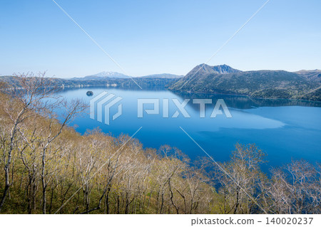 A distant view of Lake Akan, where the blue of the clear sky shines brightly. A distant view of Lake Akan, where the blue of the clear sky shines brightly. 140020237