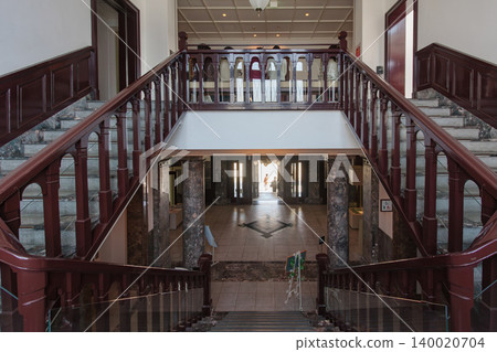 Interior photograph of the prefectural government memorial hall, capturing the grand staircase in a symmetrical composition. Interior photograph of the prefectural government memorial hall, capturing the grand staircase in a symmetrical composition. 140020704