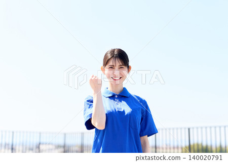 Asian caregiver strikes a triumphant pose under a blue sky Asian caregiver strikes a triumphant pose under a blue sky 140020791