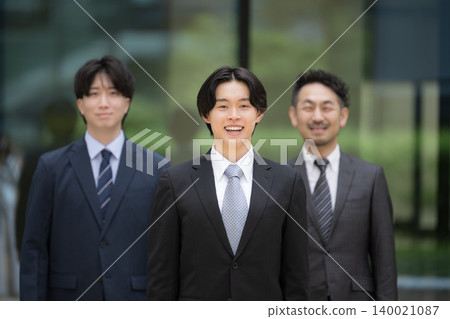 New graduates develop their skills in teams with managers, primarily focusing on younger employees; they smile and look at the camera. 140021087