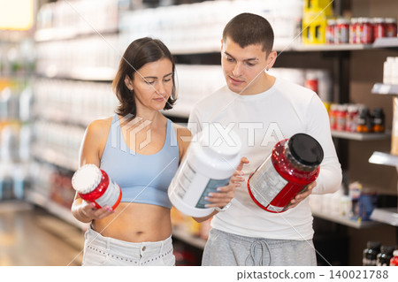 Guy and woman consult about purchasing sports nutrition, enriched protein shake Guy and woman consult about purchasing sports nutrition, enriched protein shake 140021788