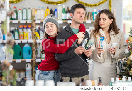 Father, mother and daughter choose toothbrush in supermarket Father, mother and daughter choose toothbrush in supermarket 140021963