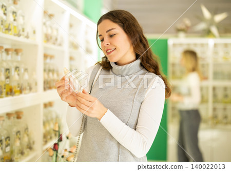 Smiling woman looking perfume for in perfume modern beauty shop 140022013