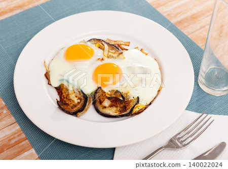 Fried sunny side up eggs with eggplant and onions 140022024