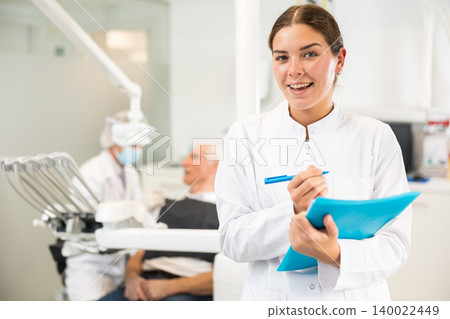 Young woman nurse taking notes in dental office Young woman nurse taking notes in dental office 140022449